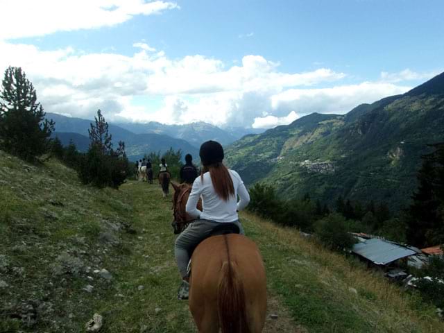 Groupe d'ados faisant du cheval à la montagne