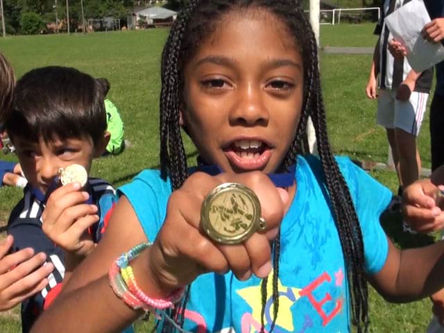 Jeune fille qui reçois sa médaille de football lors de son stage d'été