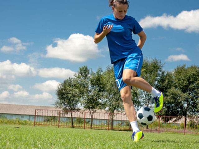 Adolescente s'entrainant au football féminin en stage sportif cet ét