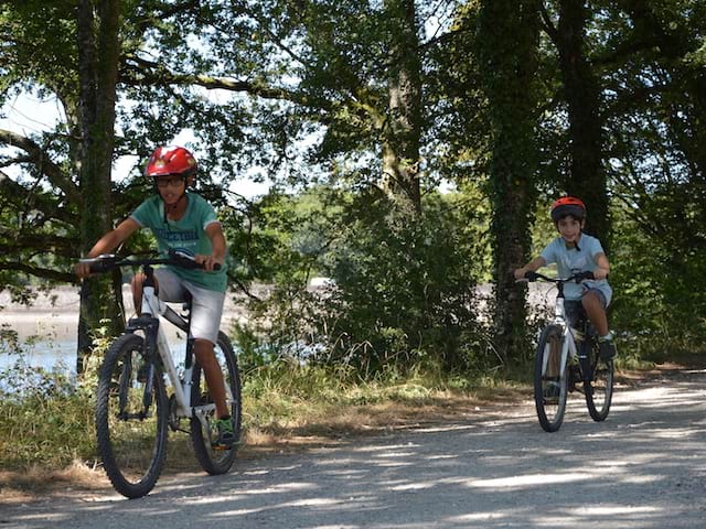 deux enfants faisant du vélo en colonie de vacances cet été 