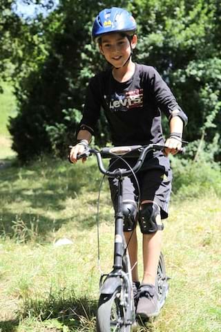 jeune garçon faisant de la trottinette tout terrain cet été