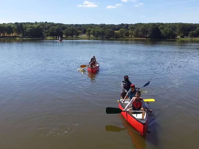 enfants sur un lac en train de faire du canoe en colonie de vacances