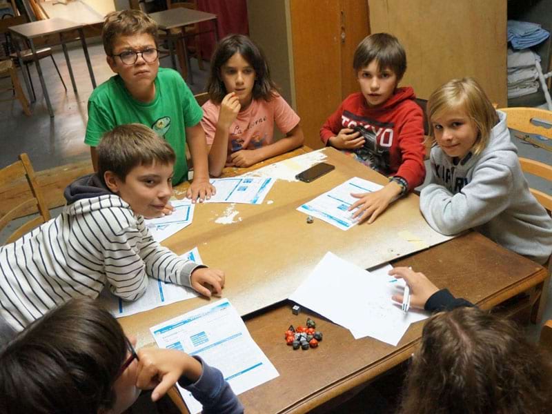 Enfant faisant un grand jeu tous ensemble en colonie de vacances jeux de roles cet été