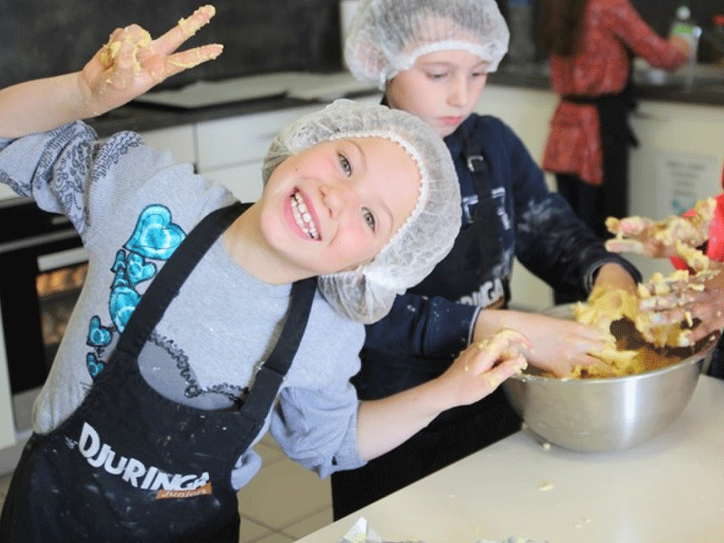 Jeunes enfants heureux d'apprendre à faire la cuisine en colonie devacances été