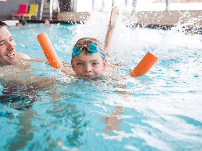 Garçonnet apprenant à nager dans une piscine en colonie de vacances été