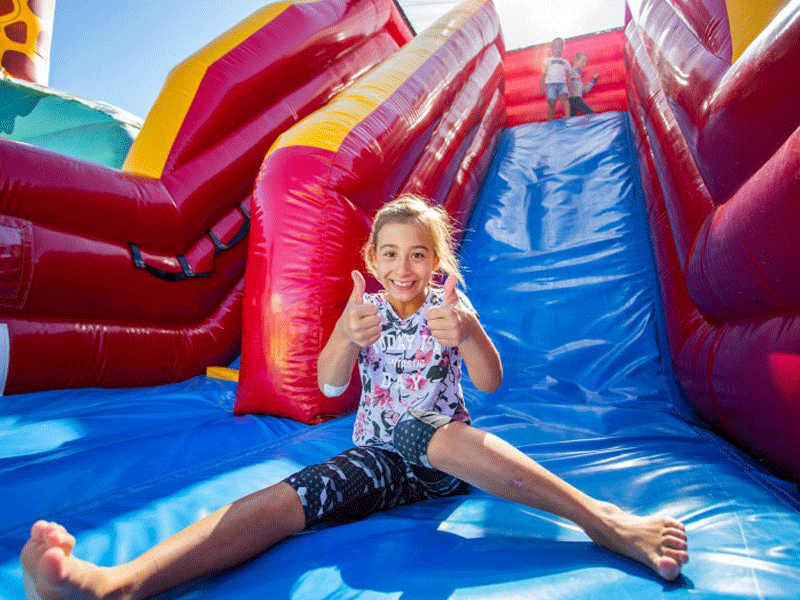 Jeune fille sur un toboggan gonflable en colonie de vacances d'été