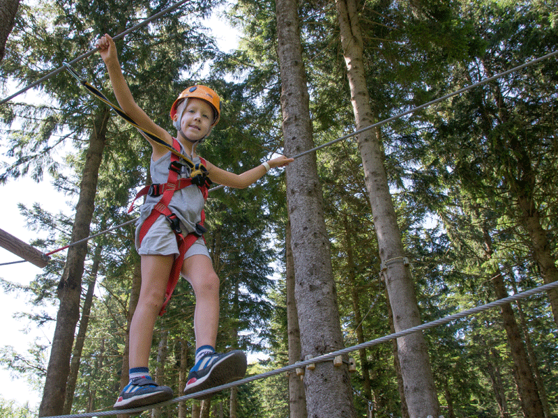 Enfant faisant de l'accrobranche en colonie de vacances été