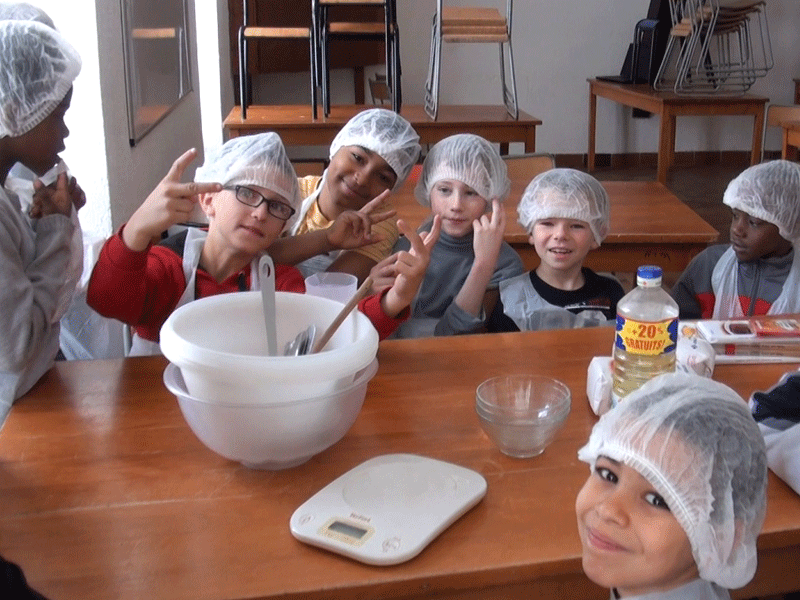 Groupe d'enfants apprenant à faire la cuisine en colonie de vacances été
