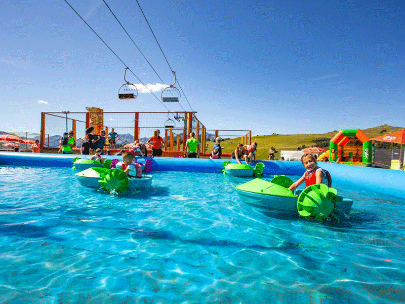 Enfants de 10 ans profitant des jeux d'eau à la montagne en colonie de vacances d'été