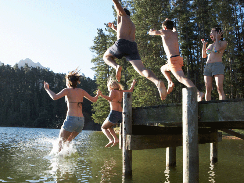 Enfants sautant à l'eau en colonie de vacances d'été à la montagne 