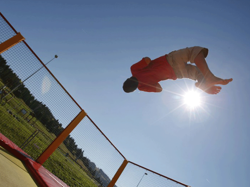 adolescent qui fait du trampoline en colonie d'été