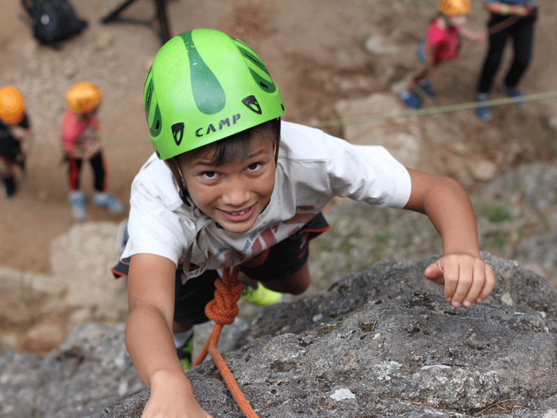 enfant faisant de l'escalade encolonie de vacances à la montagne