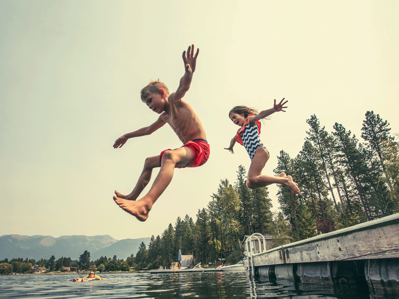 Enfants sautant à l'eau en colonie de vacances à la montagne