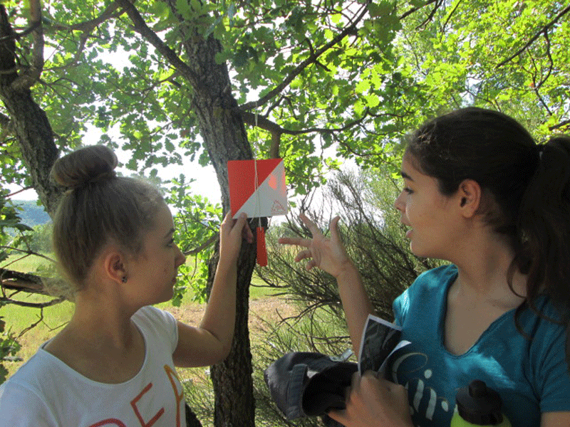 jeunes filles participant à une course d'orientation à la montagne en colonie de vacances