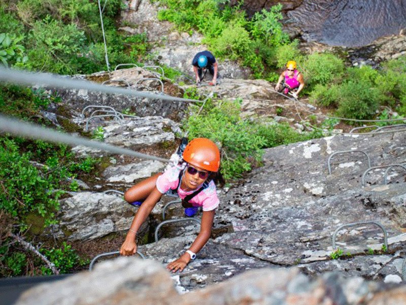 Enfants faisant de l'escalade en colonie de vacances d'été à la montagne