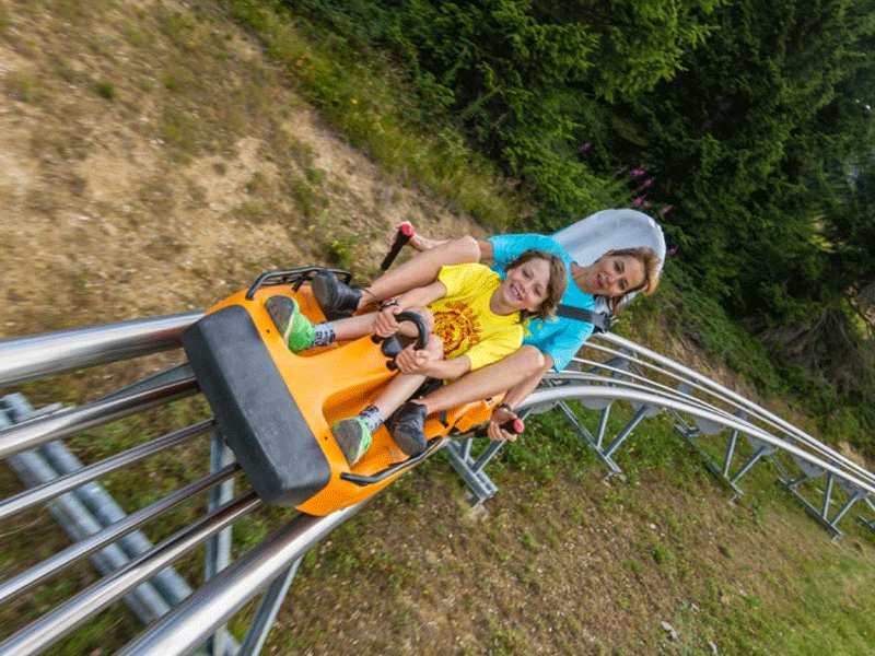 Adolescents en colo à la montagne faisant de la mountain twister une luge sur rails