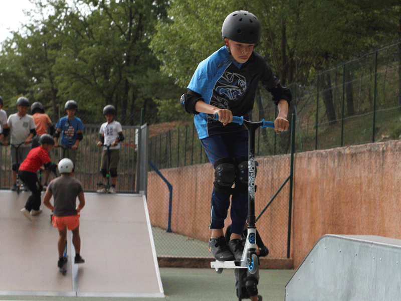 enfant faisant de la trottinette en colonie de vacances cet été