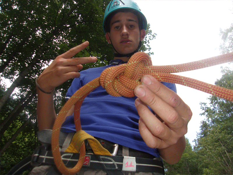 adolescent apprenant à faire un noeud de corde en colonie de vacances