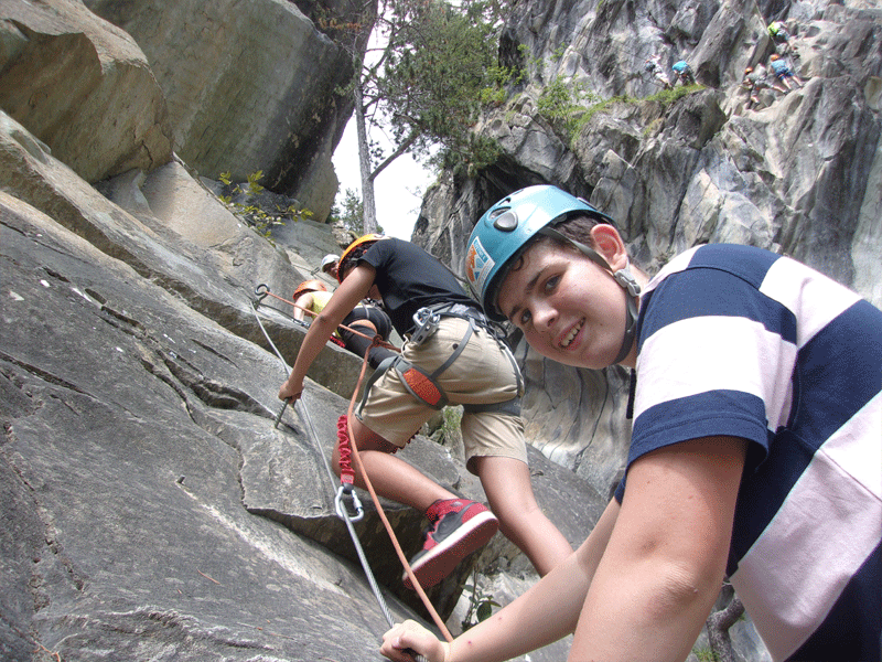 adolescents faisant de l'escalade en colonie de vacances à la montagne
