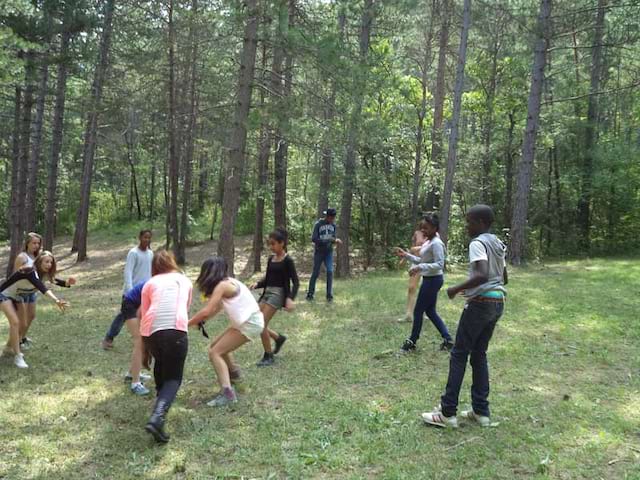 Groupe d'enfants jouant dans la forêt en colonie de vacances cet été