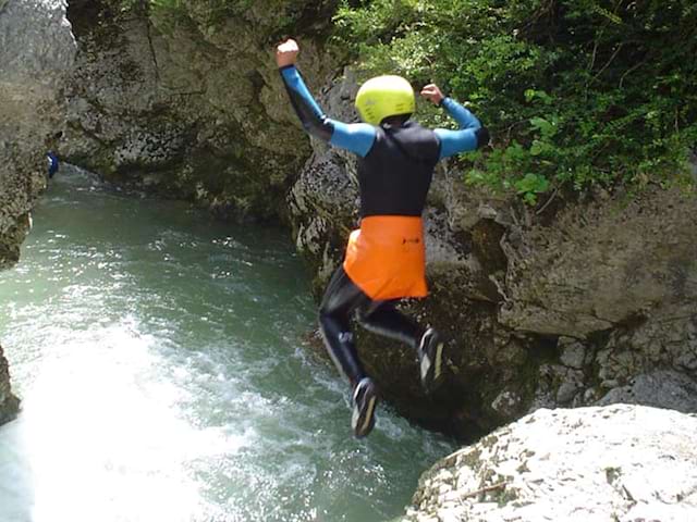 Un jeune saute d'un cascade durant l'activité via ferrata de la colonie de vacances cette été