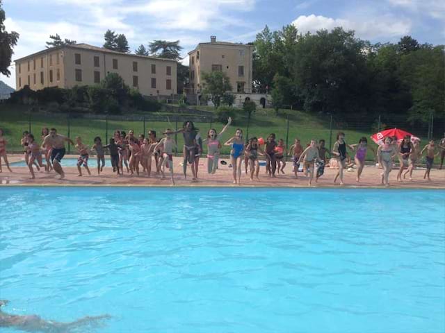 Les jeunes de la colonie de vacances tous ensemble avant de sauter dans la piscine en été