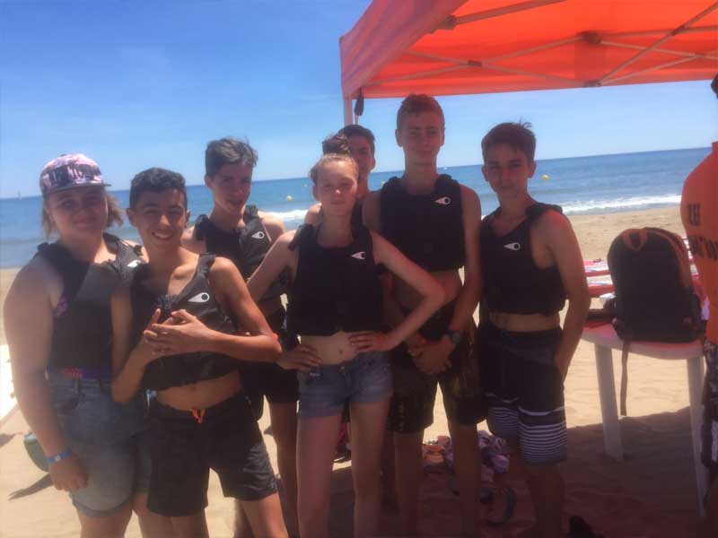 Groupe d'ados qui posent sur la plage en colonie de vacances