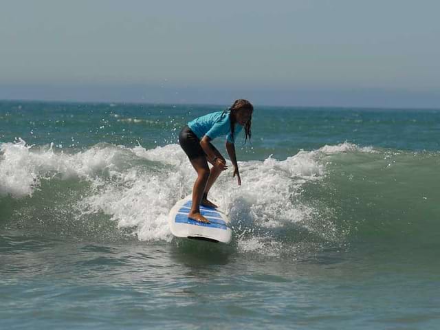 Enfant qui pratique le surf en colonie de vacances