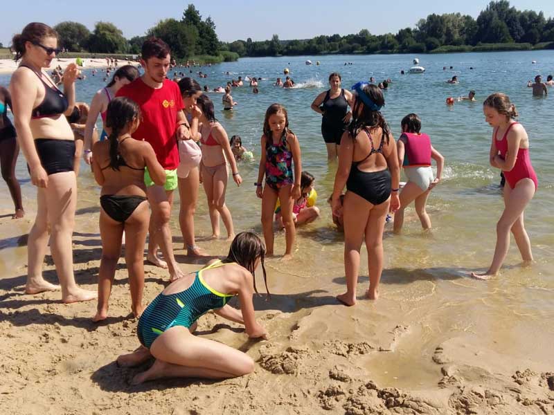 Groupe d'enfants au bord du lac en colo de vacances cet été