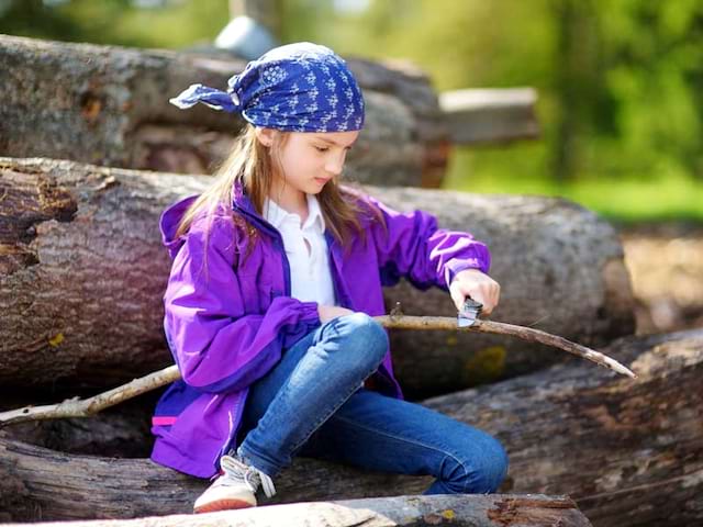 Enfant qui taille un morceau de bois