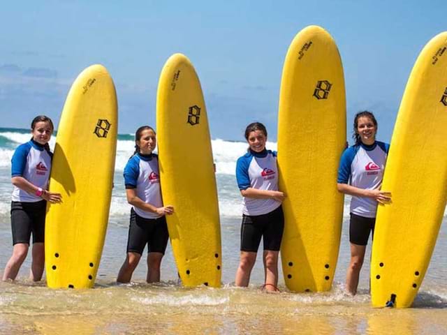 groupe d'ados avec leur planche de surf cet été