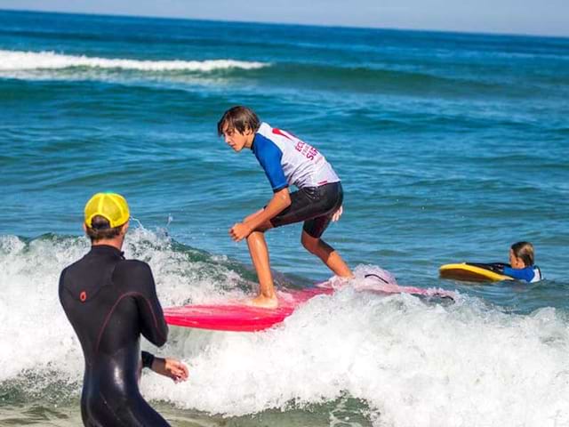 ado apprenant à surfer en colonie de vacances surf été