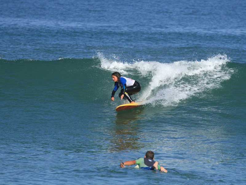 adolescent faisant du surf cet été en colonie de vacances