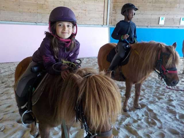 Deux enfants à cheval en colo l'été