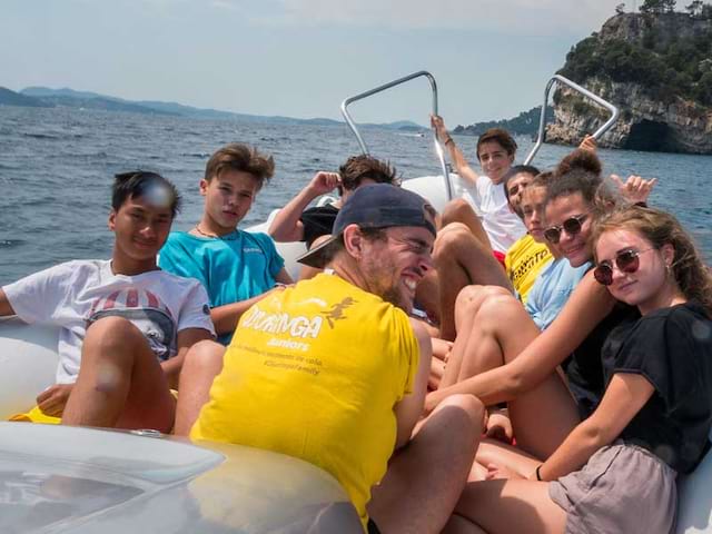 Groupe d'ados en balade en bateau en colonie de vacances cet été