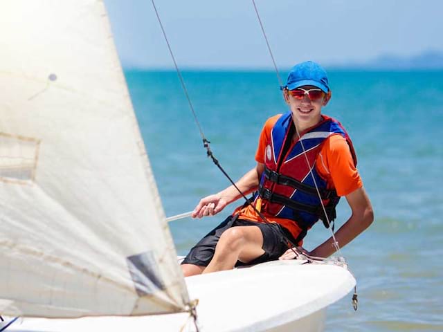 Enfant faisant de la voile en colonie de vacances à l'océan