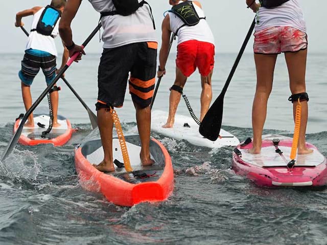 Enfants et ados faisant du paddle en colonie de vacances cet été