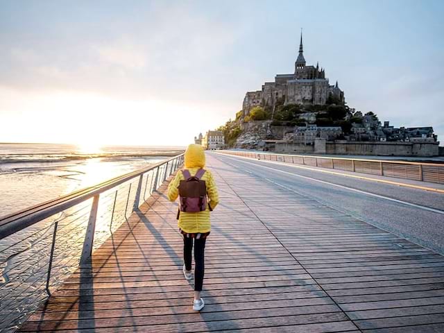 Vue sur un ado devant le Mont St Michel lors d'une colo en itinérance en Bretagne