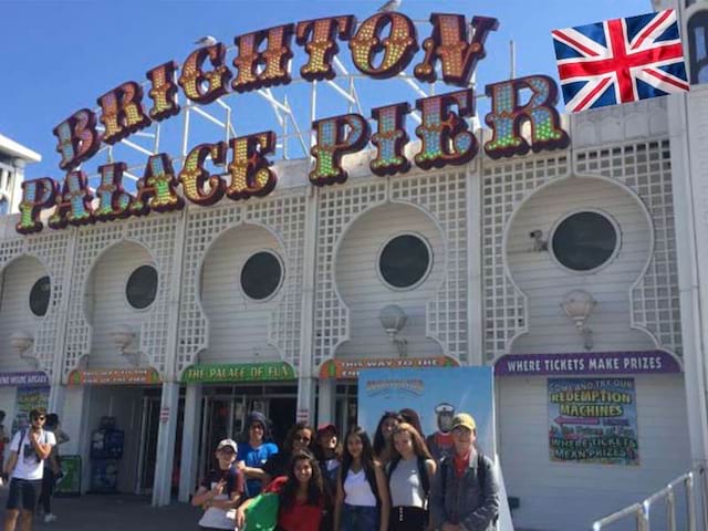 Groupe d'adolescent en colonie de vacances devant le Brighton Palace Pier en Angleterre