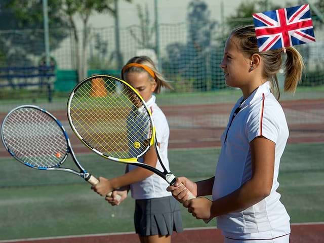 Deux enfants jouent au tennis durant leur stage linguistique anglais en Suisse