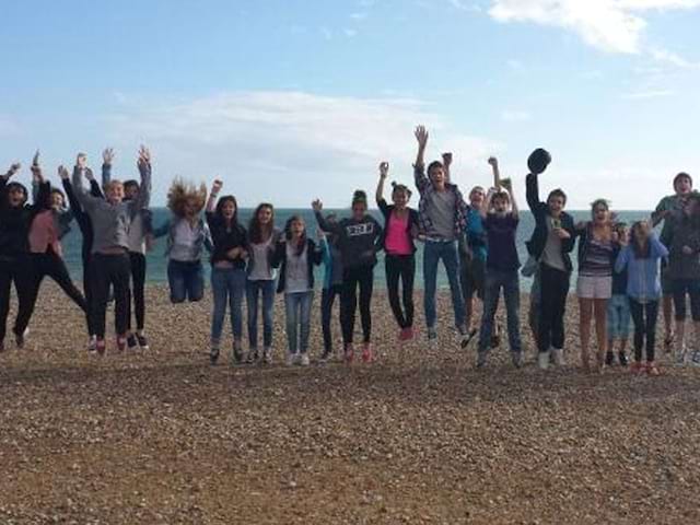 Un groupe d'adolescent en colonie de vacances linguistique s'amuse sur la plage de Brighton en Angleterre en été