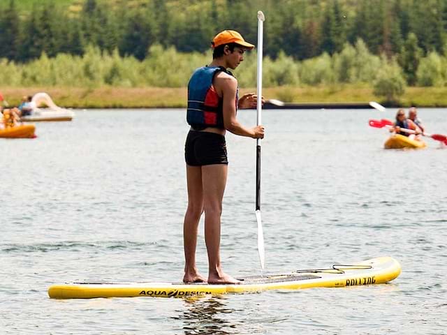 Jeune ado qui pratique le paddle en France lors d'une colonie de vacances durant l'été