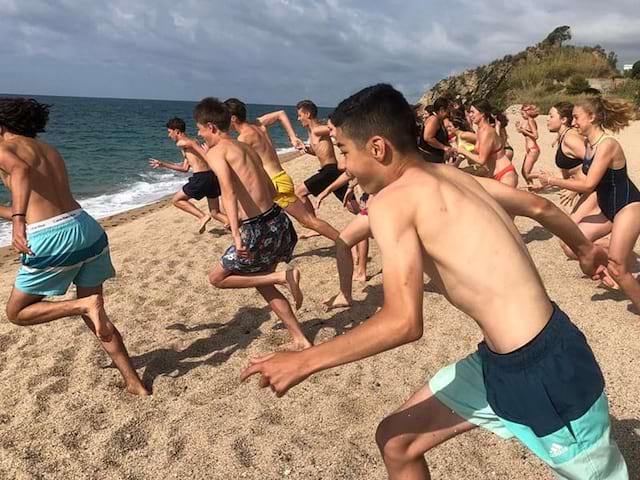 Vue sur des jeunes en colo de vacances qui courent pour se baigner