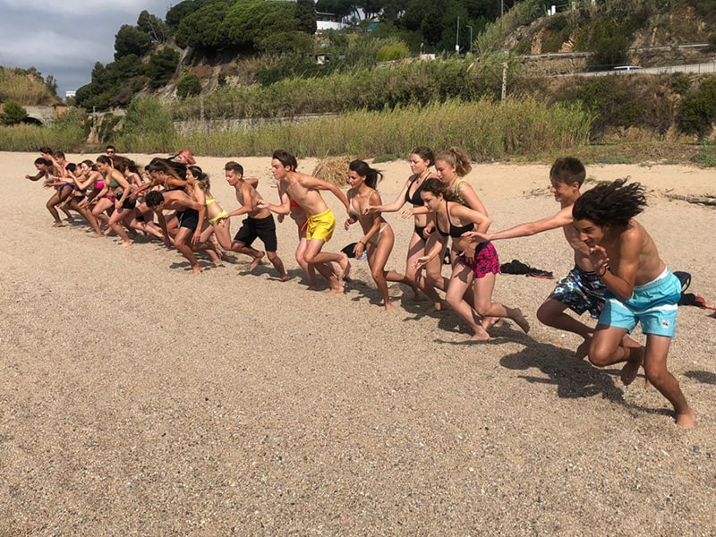Vue sur des jeunes qui courent pour se baigner lors d'une colo en Espagne