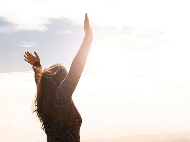 fille les bras levés dehors colo relaxation spécial ados cet été 