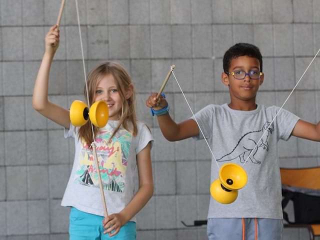 Vue sur deux enfants qui s'entraînent à la pratique du diabolo lors d'une colonie de vacances Beaux Arts et Scrapbooking