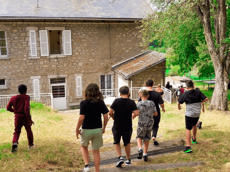 Groupe d'ados en colo de vacances qui rentrent dans leur hébergement de colo cet été