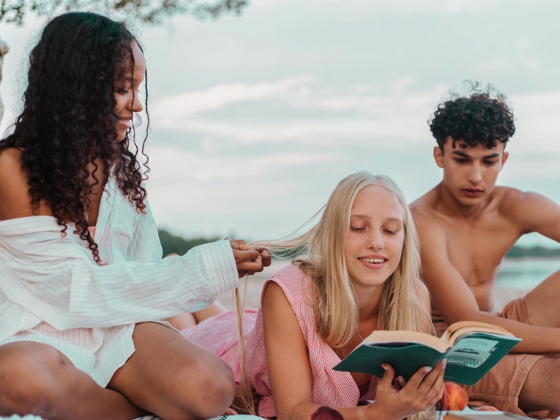 3 ados de 16 en colonie de vacances qui se reposent sur la plage durant leurs vacances du printemps