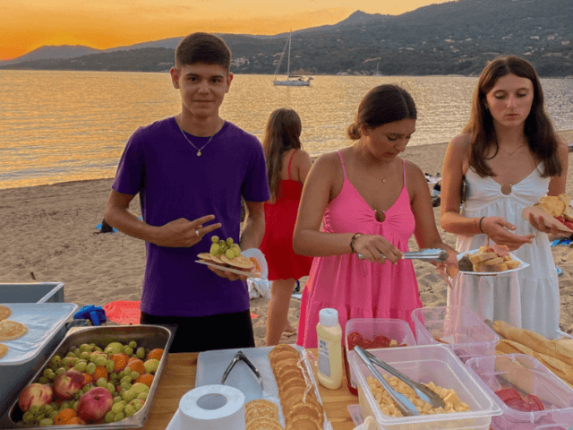 Ados en colonie de vacances qui se préparent un repas sur la plage cet été