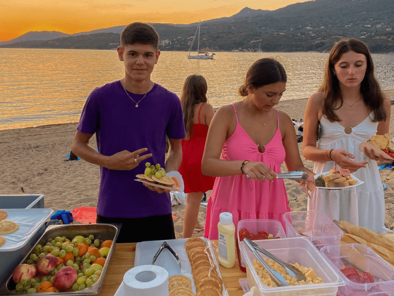 Jeunes ados sur la plage qui se font à manger lors de leur colonie de vacances La Belle Corse ouverte aux 14-17 ans